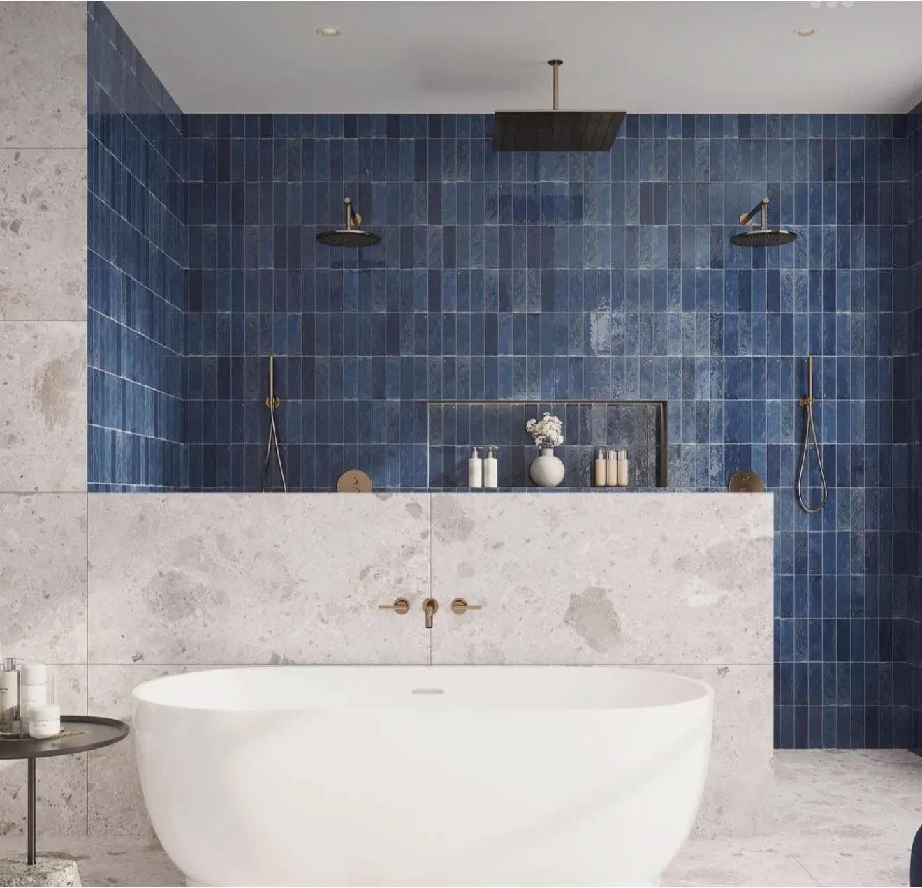 Finished statement bathroom with deep blue tile, a freestanding tub, and dual showers