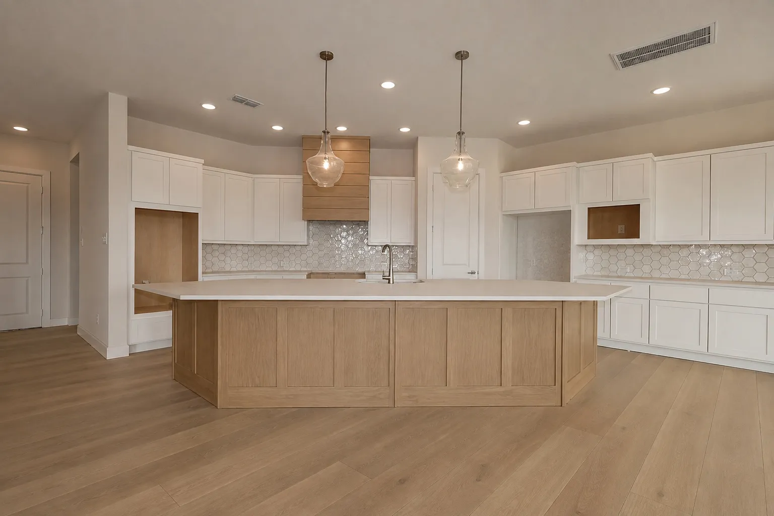 Finished luxury kitchen with wide-plank light oak flooring and a matching oak island
