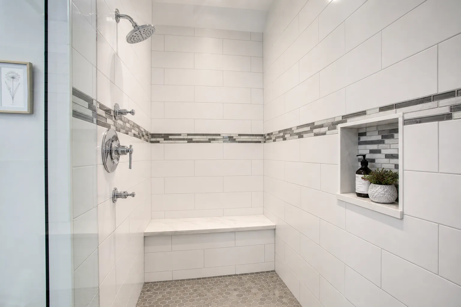 Finished white tile shower with a built-in bench and recessed niche
