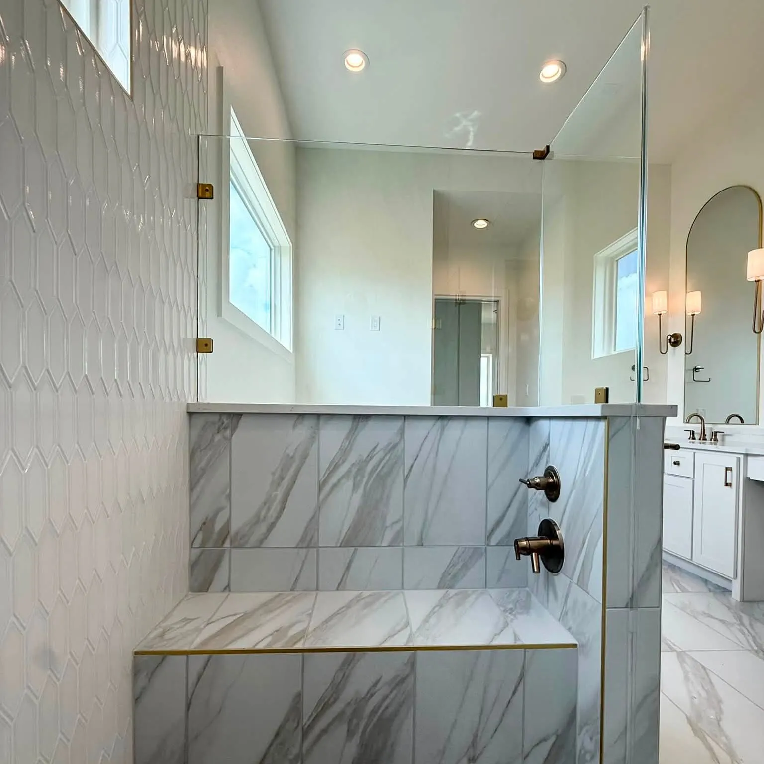 Finished marble-look walk-in shower with frameless glass